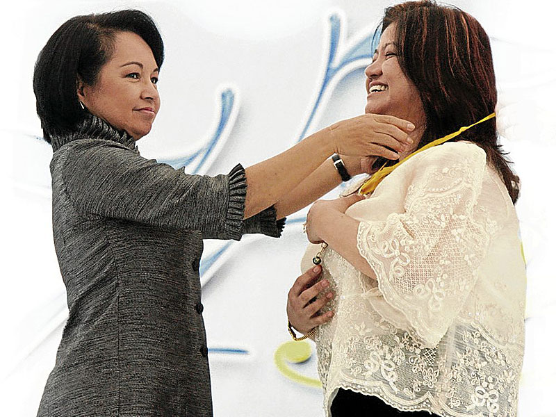 TIES THAT BIND AND BIND Former President Arroyo places the Presidential medal of merit on then PCSO Vice Chair and General Manager Rosario Uriarte in this photo taken during the 75th PCSO anniversary celebration on Sept. 8, 2009. EDWIN BACASMAS