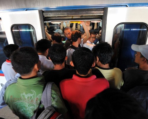 Commuters ride on the Manila Railway Transit train along Epifanio de los Santos in Manila.  AFP FILE PHOTO