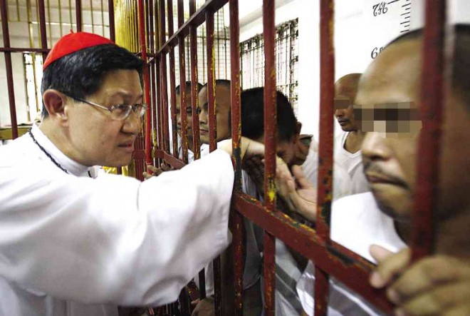 THE CARDINAL extends his hand in blessing crime suspects detained at the  Manila Police District headquarters. RAFFY LERMA 
