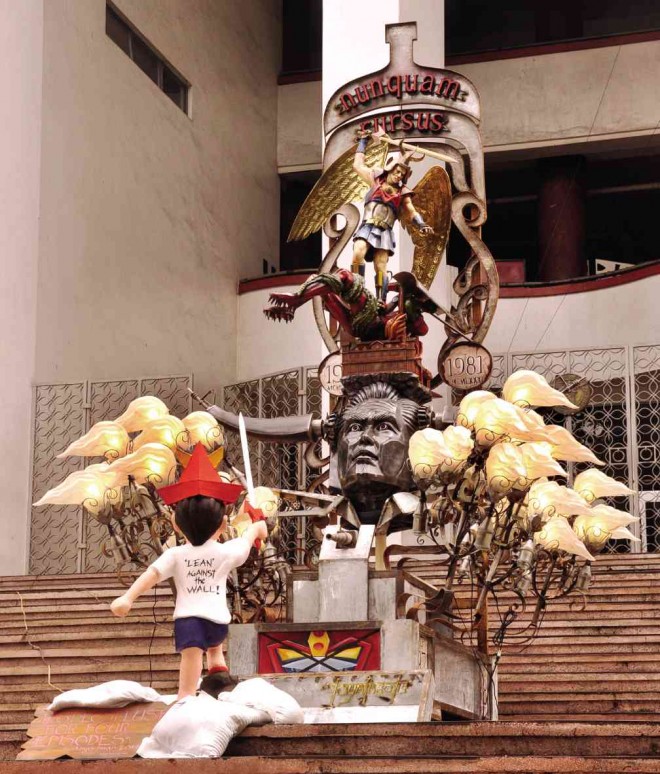 “LAST, Lost, Lust for Four Episodes,” a 13-foot sculpture by Toym Imao stands in front of the University of the Philippines’ Palma Hall in Quezon City. The artwork in brass, galvanized iron and fiberglass will be on display until Sept. 28, the 25th death anniversary of Ferdinand Marcos. CONTRIBUTED PHOTO 
