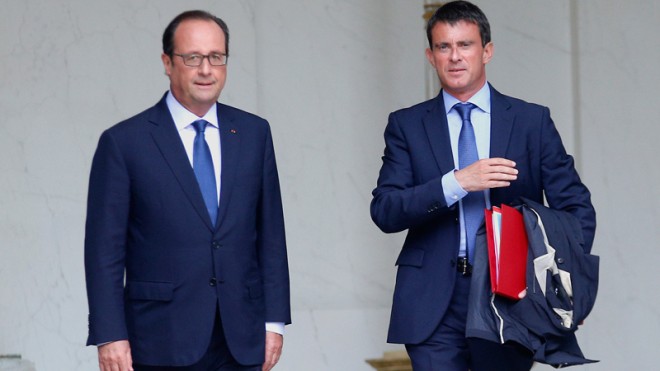 In this Aug.27, 2014 file photo, French President Francois Hollande, left, and French Prime Minister Manuel Valls leave, after the weekly cabinet meeting in Paris, France. France's prime minister faces a confidence vote Tuesday, Sept.16, 2014 in a parliament increasingly frustrated with unpopular President Francois Hollande's handling of the economy _ including dissidents within his Socialist Party. (AP Photo/Christophe Ena, File)