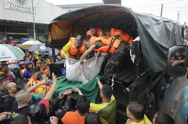Rescuers unload the body of a man who died of natural causes at the height of heavy flooding brought about by tropical storm Fung-Wong flooded Marikina city, east of Manila, Philippines and most parts of the metropolis Friday, Sept. 19, 2014. Heavy rains due to a storm and the seasonal monsoon caused widespread flooding Friday in the Philippine capital and nearby provinces, shutting down schools and government offices. (AP Photo/Bullit Marquez)