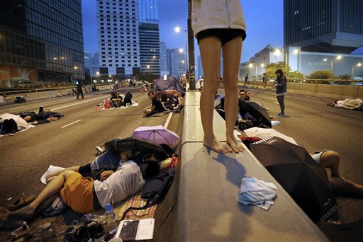 Student pro-democracy protesters sleep, rest and wait on the streets near the government headquarters at the break of dawn, Sunday, Oct. 5, 2014, in Hong Kong. AP