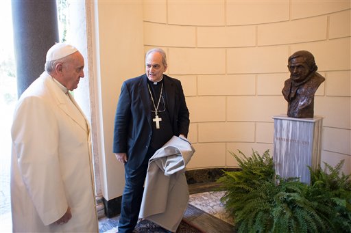 In this file photo provided by the Vatican newspaper L'Osservatore Romano on Oct. 27, 2014, Pope Francis is flanked by Chancellor of the Pontifical Academy of Sciences, Mons. Marcelo Sanchez Sorondo, during the unveiling of a bronze bust of Pope Emeritus Benedict XVI, at the Vatican. AP