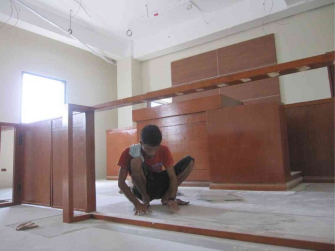 A CONSTRUCTION worker puts on the finishing touches on one of the courtrooms at Qimonda IT Center in Cebu City. Judges and court employees are set to transfer to the newly constructed courtrooms next month. ADOR VINCENT MAYOL 