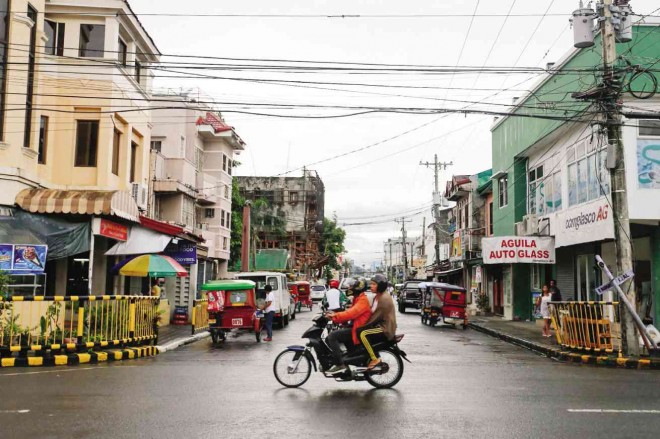 BEFORE  Motorcycles try to navigate Real Street in Tacloban amid  debris and garbage left by Supertyphoon “Yolanda” a year ago today. The same street as above photo as it looked amid the ruins.  ANDREW TADALAN
