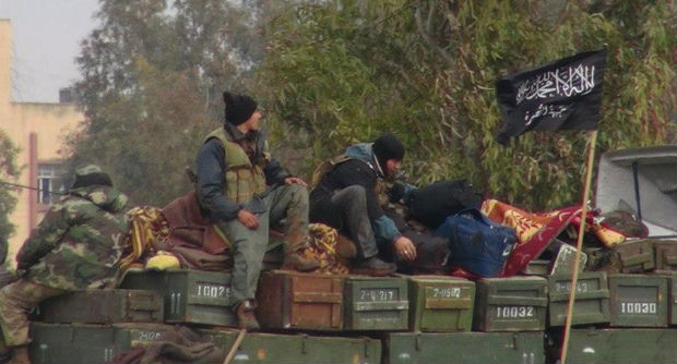 In this Friday, Jan. 11, 2013 file photo, citizen journalism image provided by an anti-Bashar Assad activist group Edlib News Network (ENN), which has been authenticated based on its contents and other AP reporting, rebels from al-Qaida-affiliated Jabhat al-Nusra, also known as the Nusra Front, sit on a truck full of ammunition at Taftanaz air base, that was captured by the rebels in Idlib province, northern Syria. AP