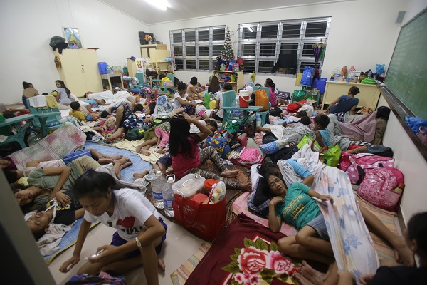 Filipino families seek refuge at a school used as an evacuation center as they prepare for Typhoon Hagupit in Legazpi, Albay province, eastern Philippines Saturday, Dec. 6, 2014. AP
