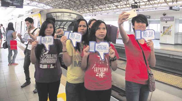 SELFIE PROTEST  Members of #StrikeTheHike protest light-rail fare increases at LRT-2 Pureza Station in Sta. Mesa, Manila, on Sunday. The group urges commuters to protest the fare hikes by taking selfies and “groupfies” at train stations.  JOAN BONDOC
