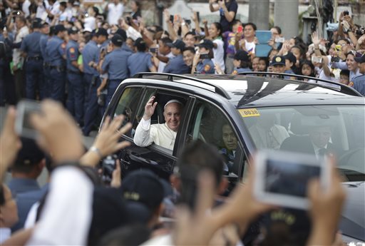 Pope Francis waves to Filipinos after mass at Cathedral Basilica of the Immaculate Conception in Manila, Philippines on Friday, Jan. 16, 2015. Pope Francis called Friday for authorities to reject the corruption that has plagued this Asian nation for decades and urged them to instead work to end its "scandalous" poverty as he brought his message of social justice to Filipinos who cheered him wildly at every turn.(AP Photo/Aaron Favila)