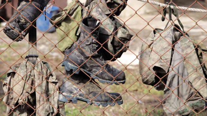 THEY DIED WITH THEIR BOOTS ON  Uniforms and combat shoes of policemen slain in a clash with Moro rebels are hung at the morgue of the Army’s 6th Infantry Division in Datu Odin Sinsuat town in Maguindanao province.  JEOFFREY MAITEM/INQUIRER MINDANAO