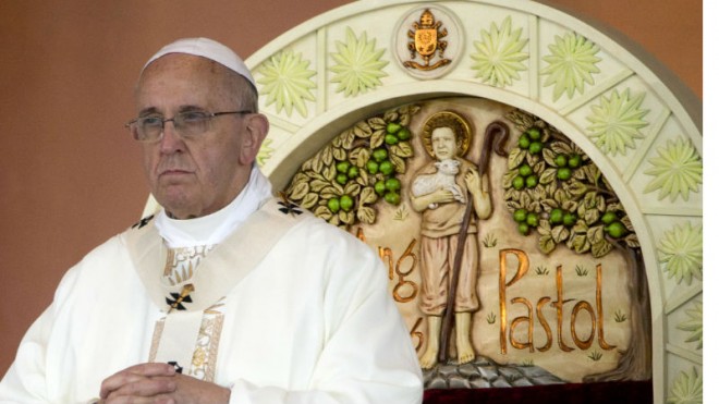 Pope Francis prays during a Mass at Rizal Park, in Manila, Philippines, Sunday, Jan. 18, 2015. Millions filled Manila's main park and surrounding areas for Pope Francis' final Mass in the Philippines on Sunday, braving a steady rain to hear the pontiff's message of hope and consolation for the Southeast Asian country's most downtrodden and destitute. (AP Photo/Alessandra Tarantino)
