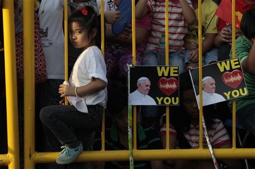 A young girl waits behind a fence for hours for the arrival of Pope Francis in Manila, Philippines, Thursday, Jan. 15, 2015. AP