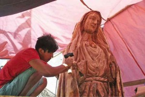 A wood-carver from Kalayaan town, Laguna province, helps carve a majestic image of the Virgin Mary and San Ildefonso out of the dead tree.