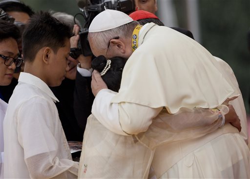 Pope Francis hugs two former street children during his meeting with youths in Santo Tomas University in Manila, Philippines, Sunday, Jan. 18, 2015. AP