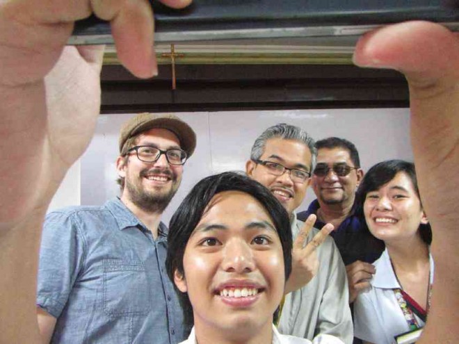 Baumann (in beret) takes a selfie with fellow cartoonists Pabalinas and Aranda and students.