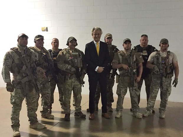 In this photo provided on Monday, May 4, 2015 by Geert Wilders, Dutch lawmaker Geert Wilders, leader of the anti-Islam Freedom Party, center, poses for a photograph with police officers who responded to a shooting outside a provocative contest for cartoon depictions of Prophet Muhammad in Garland, Texas. Two gunmen were killed Sunday, May 3, 2015 in Texas after opening fire on a security officer outside a provocative contest for cartoon depictions of Prophet Muhammad, and a bomb squad was called in to search their vehicle as a precaution, authorities said. (Geert Wilders via AP)