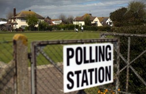 People play bowls by a polling station sign at Birchington Bowls Club in Birchington, south east England, Thursday, May 7, 2015. Polls have opened in Britain's national election, a contest that is expected to produce an ambiguous result, a period of frantic political horse-trading and a bout of national soul-searching. AP