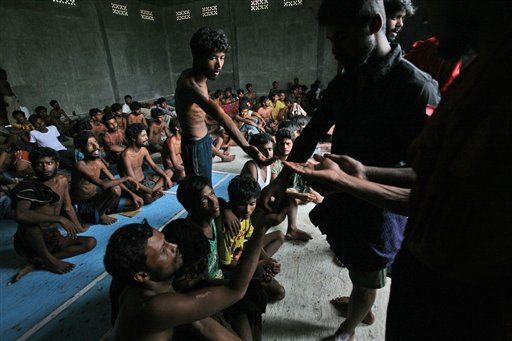 A migrant distributes sweets to others after their arrival at Kuala Langsa Port in Langsa, Aceh province, Indonesia, Friday, May 15, 2015. More than 1,000 Bangladeshi and ethnic Rohingya migrants came ashore in different parts of Indonesia and Thailand on Friday, becoming the latest refugees to slip into Southeast Asian countries that have made it clear the boat people are not welcome. AP