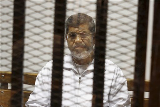 In this May 8, 2014 file photo, Egypt's ousted Islamist President Mohammed Morsi sits in a defendant cage in the Police Academy courthouse in Cairo, Egypt.  AP