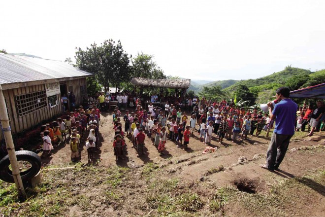 Lumad students form lines for a flag-raising ceremony at the Salugpungan Ta Tanu Igkanugon Community Learning Center, which a tribal leader claims the military wants burned for being run by communist guerrillas. KARLOS MANLUPIG/INQUIRER MINDANAO 