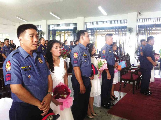 Six Quezon City police officers reaffirm their commitment to their spouses in a mass renewal of wedding vows sponsored by top-ranking QC police officials at Camp Karingal, Quezon City. PHOTO BY JINKY CABILDO 