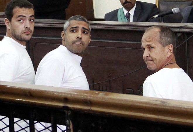FILE - In this March 31, 2014 file photo, Al-Jazeera English producer Baher Mohamed, left, Canadian-Egyptian acting Cairo bureau chief Mohammed Fahmy, center, and correspondent Peter Greste, right, appear in court along with several other defendants during their trial on terror charges, in Cairo. An Egyptian court on Saturday, Aug. 29, 2015, sentenced the three Al-Jazeera English journalists to three years in prison. (AP Photo/Heba Elkholy, El Shorouk, File) EGYPT OUT