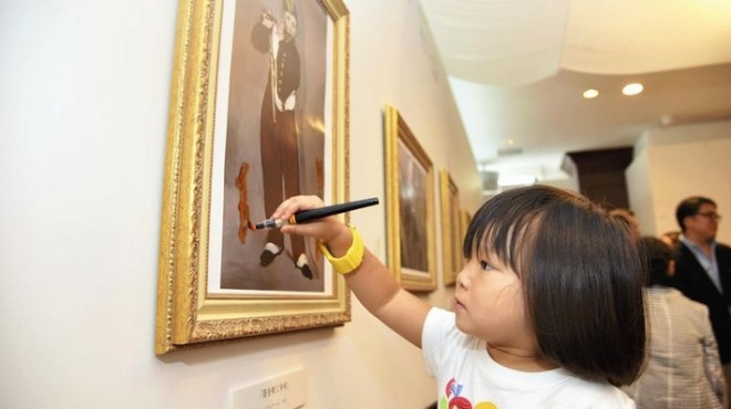 A child enjoys drawing on a replica of a famous painting. PHOTO BY THE YOMIURI SHIMBUN