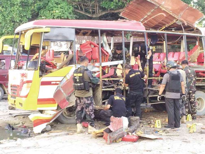 MILITARY and police bomb experts inspect the blasted bus in Zamboanga City where an 11-year-old girl died and at least  31 others were wounded on Friday.     JULIE ALIPALA/INQUIRER MINDANAO