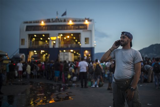  In this photo taken on Wednesday, Sept. 9, 2015, Mohammed al-Haj from Syria speaks on his cell phone before his departure to Athens' port of Piraeus from Mytilene port, on the northeastern island of Lesbos, Greece.  Mohammed, a 26-year-old from Aleppo, was one of more than 600,000 migrants and refugees who flowed into Europe so far this year. The Associated Press followed Mohammed on nearly every step of his 2,500-mile journey in September, starting from Killis, Turkey, where his family lived for a year after escaping Syria.(AP Photo/Santi Palacios)