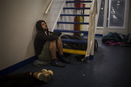 In this photo taken early Thursday, Sept. 10, 2015, Mohammed al-Haj from Syria sleeps on the deck of a ferry as he travels from the northeastern Greek island of Lesbos to Athens. Mohammed, a 26-year-old from Aleppo, was one of more than 600,000 migrants and refugees who flowed into Europe so far this year. The Associated Press followed Mohammed on nearly every step of his 2,500-mile journey in September, starting from Killis, Turkey, where his family lived for a year after escaping Syria. (AP Photo/Santi Palacios)