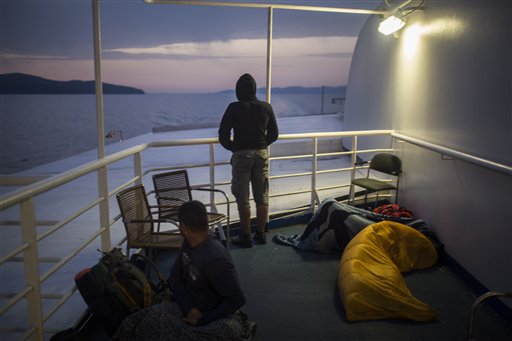In this photo taken early Thursday, Sept. 10, 2015, Mohammed al-Haj from Syria looks to the sea on the deck of a ferry traveling from the northeastern Greek island of Lesbos to Athens. Mohammed, a 26-year-old from Aleppo, was one of more than 600,000 migrants and refugees who flowed into Europe so far this year. The Associated Press followed Mohammed on nearly every step of his 2,500-mile journey in September, starting from Killis, Turkey, where his family lived for a year after escaping Syria. (AP Photo/Santi Palacios)