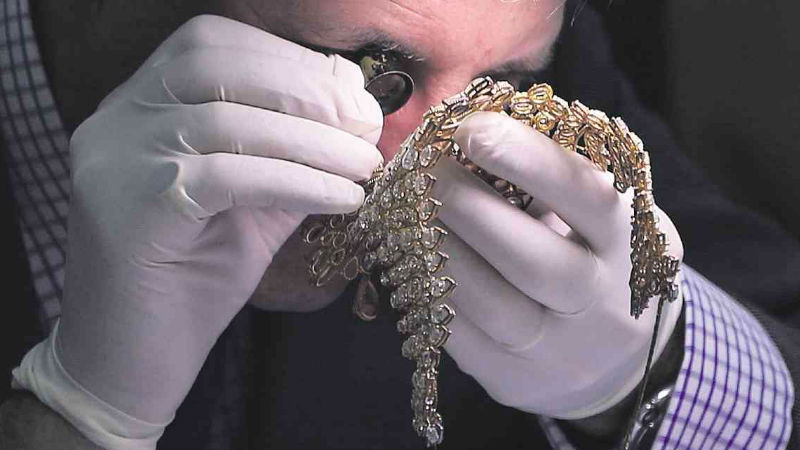 ALL THAT GLITTERS  Christie’s auction house appraiser David Warren closely examines a neckpiece from the Roumeliotes collection, one of a three-set jewelry collection seized from the Marcoses after the family fled to Hawaii following the Edsa People Power Revolution in 1986. The government has asked Christie’s and its rival, Sotheby’s, to appraise some 700 pieces of Marcos jewelry for a possible auction after being kept for almost 30 years in a Central Bank vault. EDWIN BACASMAS