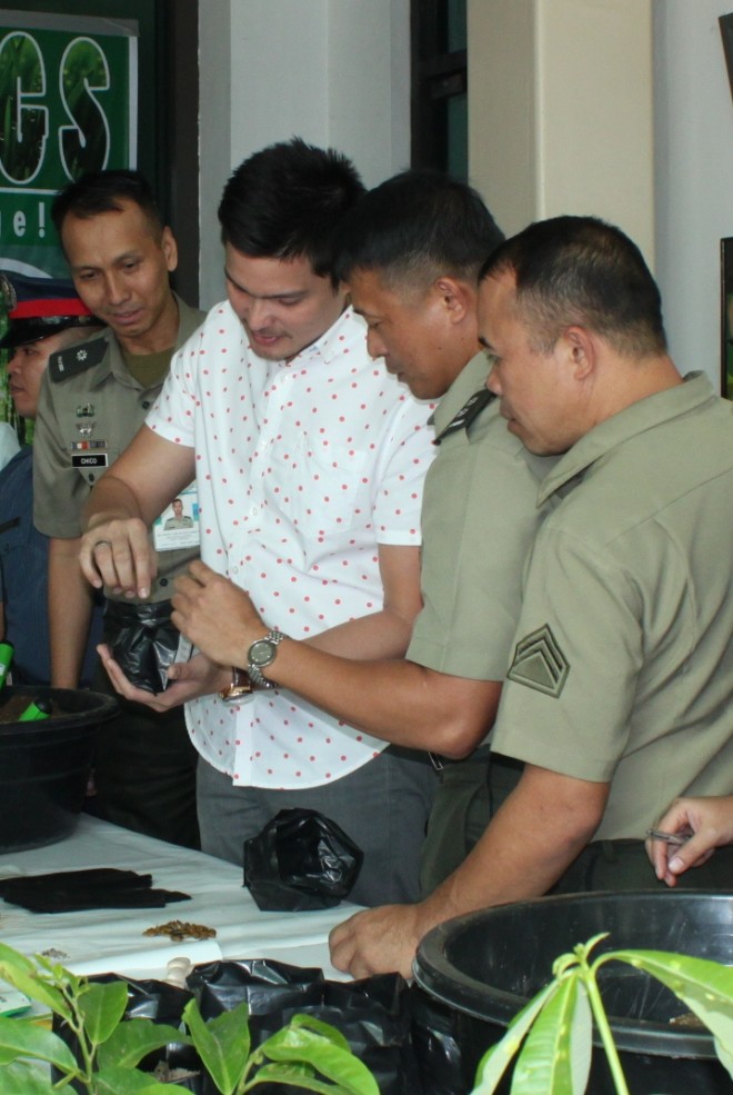 National Youth Commissioner and actor Dingdong Dantes is assisted in making his own seedling at the soft launch of the "Race to 1,000,000 Seedlings" during the Climate Change Summit in Camp General Emilio Aguinaldo on December 7./ AFP PAO