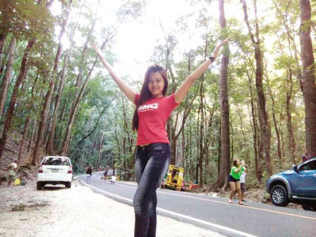 VISITORS, like this woman, take selfies with a mahogany forest in Bohol province as background, unmindful of the risks of stopping in the middle of the road with no signs telling motorists to slow down.   LEO UDTOHAN/INQUIRER VISAYAS 