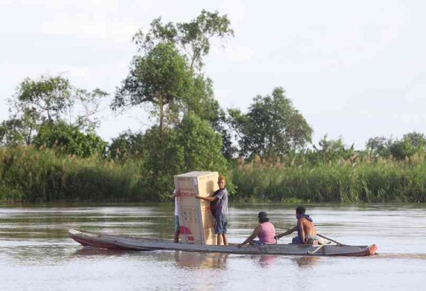 THERE’S NO STOPPING this family from bringing home their new appliance unit, a refrigerator, at the height of flooding brought by Typhoon ‘Nona’ during the Christmas holidays. The boat carries the family across the Pampanga River in Barangay Bebe Anac in the town of Masantol in Pampanga province. LYN RILLON