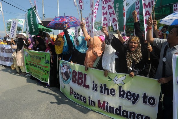Philippine Muslims holding placards with slogans supporting the peace accord between the government and the Moro Islamic liberation Front (MILF) shout slogans during a rally to press for the passage of the Bangsamoro Basic law that will implement the peace treaty in front of the Philippine Senate on June 3, 2015. Muslim rebels have been battling for independence or autonomy in the southern islands of the mainly Catholic Philippines since the 1970s, and as part of the deal, the MILF is to disarm and President Benigno Aquino is set to legislate an area of Muslim self-rule.   AFP PHOTO / Jay DIRECTO / AFP / JAY DIRECTO