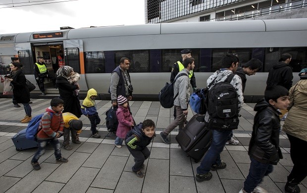 FILE - In this Thursday Nov. 12, 2015, file photo, a group of migrants disembark from a train at the Swedish end of the bridge between Sweden and Denmark in Malmo, Sweden. On upcoming Monday Jan. 4, 2016, new travel restrictions are set to be imposed by Sweden to stem a record flow of migrants, transforming the Oresund bridge between Sweden and Denmark into a striking example of how national boundaries are re-emerging.(Stig Ake Jonsson/TT via AP, FILE) SWEDEN OUT