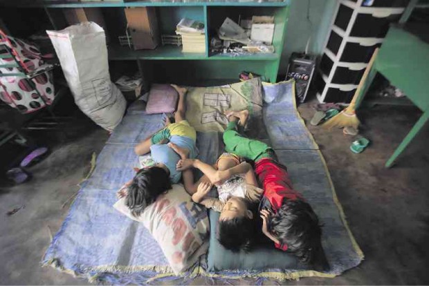 CHILDREN of families living in coastal areas in Bicol take shelter in a school-turned-evacuation center at the height of Typhoon “Nona,” which destroyed or damaged hundreds of classrooms across the region. MARK ALVIC ESPLANA / INQUIRER SOUTHERN LUZON