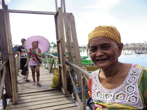 AN ELDERLY Badjao woman guides the Inquirer  to the Buggoc Transitory Site in Barangay Santa Catalina in Zamboanga City. A wooden bridge leads to houses on stilt. The entrance serves as gate to the new Badjao community. JULIE S. ALIPALA