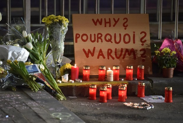 A sign reads "Why?" in English, French and Flemish behind candles and flowers near the Maelbeek metro station, in Brussels on Wednesday evening, March 23, 2016. Bombs exploded Tuesday at Brussels airport and one of the city's metro stations, killing and wounding scores of people, as a European capital was again locked down amid heightened security threats. AP