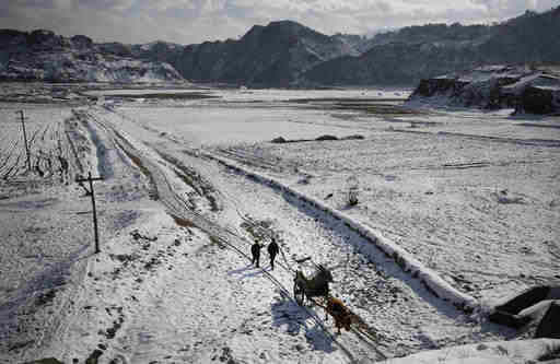 In this Thursday, Dec. 3, 2015, photo, farmers transport their supplies in an oxcart while the Chongchon River No. 10 Hydroelectric Power Station is seen in the background in Ryongyon-ri in Kujang county, North Korea. "Until They Are Home" is one of the most sacred vows of the U.S. military, yet there are 5,300 American GIs missing in North Korea from the Korean War whose remains are potentially recoverable. It has been more than a decade since any U.S. search teams have tried, and with construction projects across the country moving forward, many could already be lost forever. (AP Photo/Wong Maye-E)