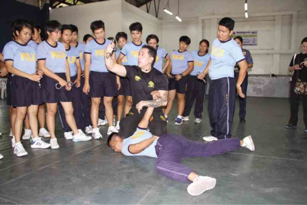 ‘REAL-LIFE SCENARIO’ Dindo De Jesus (in black) teaches female NCRPO trainees how to subdue and handcuff an arrested person the Krav Maga way. NCRPO PHOTO