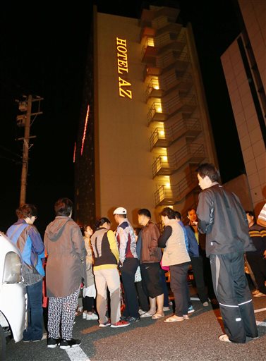People gather outside a hotel after an earthquake in Kumamoto, southern Japan, Thursday, April 14, 2016.  A powerful earthquake with a preliminary magnitude of 6.4 has struck southern Japan. Japan's Meteorological Agency said the quake hit at 9:26 p.m. (1226 GMT) and was centered in the Kumamoto prefecture. (Kyodo News via AP) JAPAN OUT, MANDATORY CREDIT