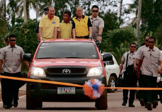 THREE FOR THE ROAD President Aquino motors to Basilan with PublicWorks Secretary Rogelio Singson (left) and ARMM Gov. Mujiv Hataman (second from left), for the inauguration of the Basilan Circumferential Road in Barangay Tumahubong, Sumisip, onMarch 21. MALACAÑANG PHOTO