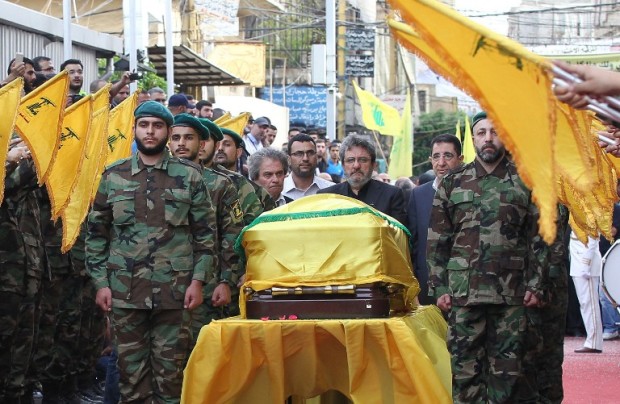 Adnan (C-L) and Hassan Badreddine (C-R), brothers of slain top Hezbollah commander Mustafa Badreddine who was killed in an attack in Syria, mourn next to his casket during the funeral  in the Ghobeiry neighbourhood of southern Beirut on May 13, 2016. Hezbollah announced that Badreddine had been killed in an attack in Syria where the Shiite militant group has deployed thousands of fighters in support of the Damascus regime. The group said it was still investigating the cause of the blast near Damascus airport but it did not immediately point the finger at Israel as it did when the commander's predecessor was assassinated in the Syrian capital in 2008. / AFP PHOTO / ANWAR AMRO
