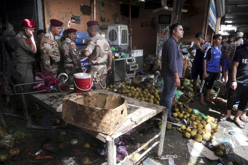 Security forces and citizens inspect the scene after a bomb explosion at an outdoor market in Baghdad's northern neighborhood of Shaab, Iraq, Tuesday, May 17, 2016. A bomb at an outdoor market in a Shiite-dominated Baghdad neighborhood on Tuesday, killing and wounding dozens of civilians, a police official said, the latest in a wave of deadly militant attacks far from the front lines in the country's north and west where Iraqi forces are battling the Islamic State group. AP 