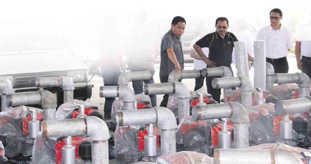 AGRICULTURE Secretary Emmanuel Piñol (center) takes a look at submersible pumps that have been left unused and stored at the compound of the regional Department of Agriculture office in Tupi town, South Cotabato province. CONTRIBUTED PHOTO