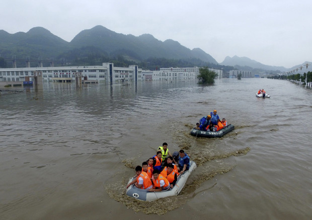 In this photo taken Tuesday June 28, 2016, rescuers evacuate residents trapped by flood waters in Zhijin county, southwest China's Guizhou province. Chinese state media reported Tuesday that heavy rain continue to wreak havoc in southern China forcing thousands of residents to be evacuated. (Chinatopix Via AP) CHINA OUT