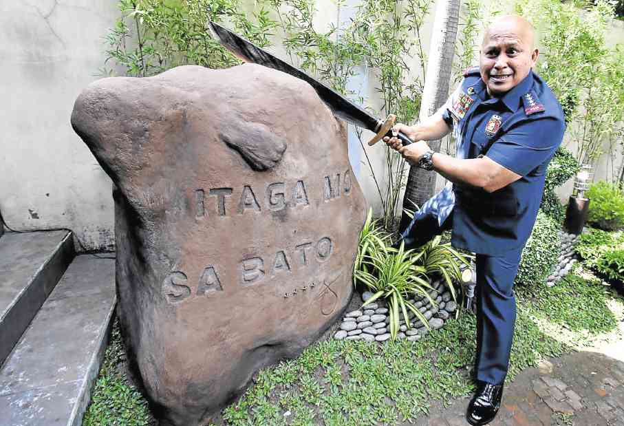 MEANWHILE, AT CAMP CRAME...  A bolo-wielding Philippine National Police chief, Director General Ronald “Bato ” dela Rosa, shows his clowning chops during the launch on Monday of the PNP’s newest project, a reporting and quick-response app dubbed  Itaga Mo Sa Bato.  RICHARD REYES 